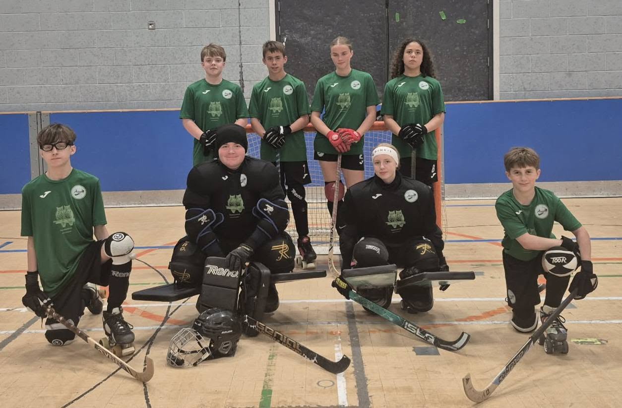 A mixed junior squad kneeling with sticks before a league game